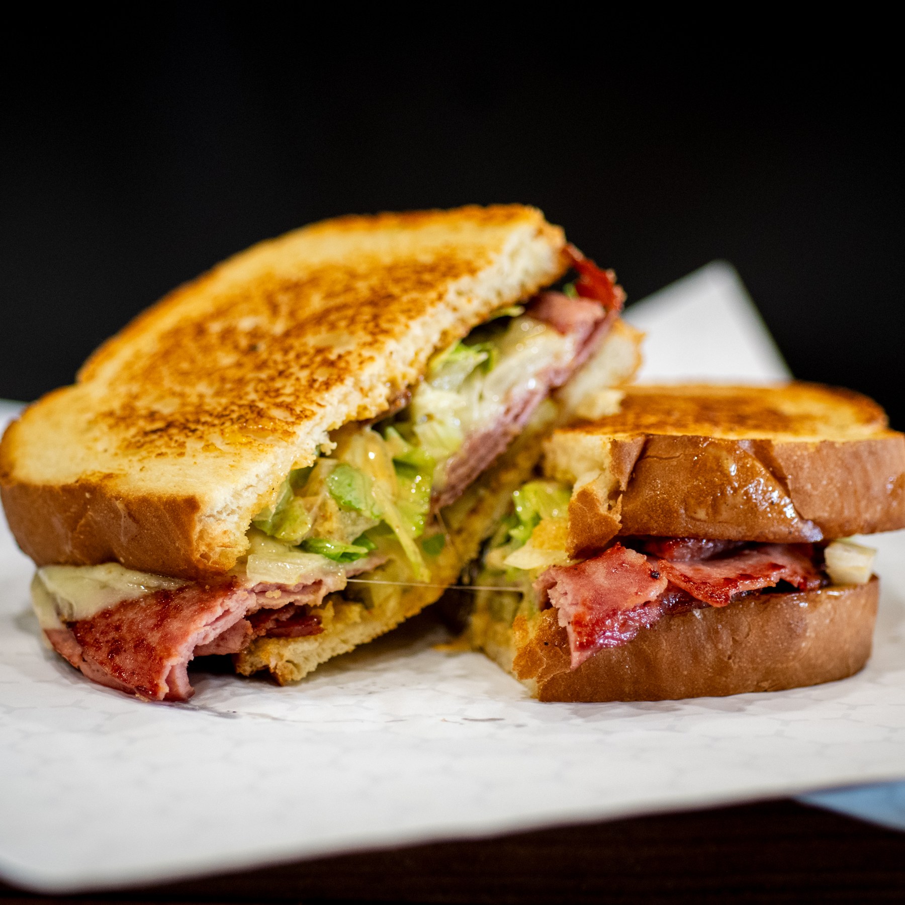 A close view of a toasted bologna sandwich
