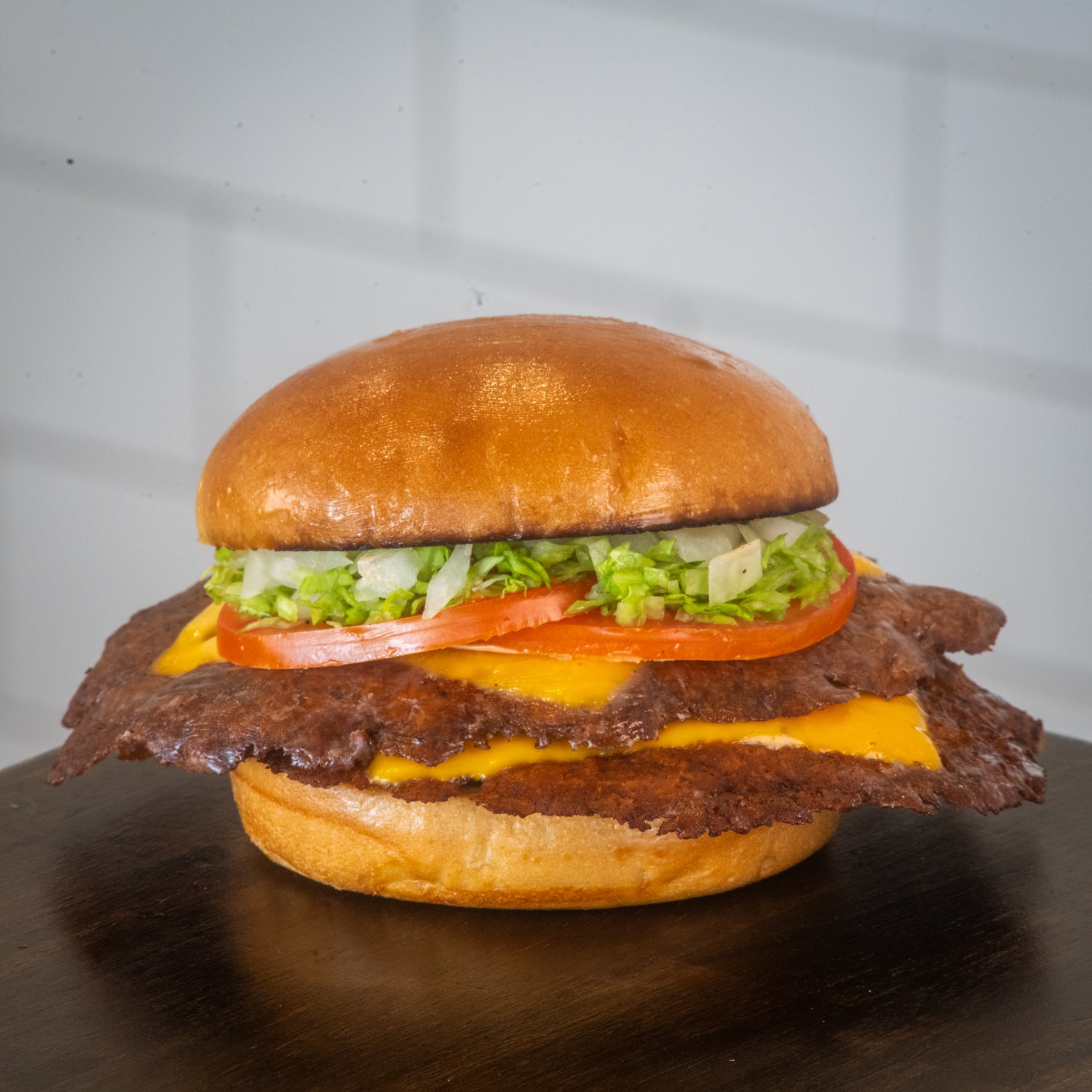 Double smash burger with cheese, lettuce, tomato, and a golden bun